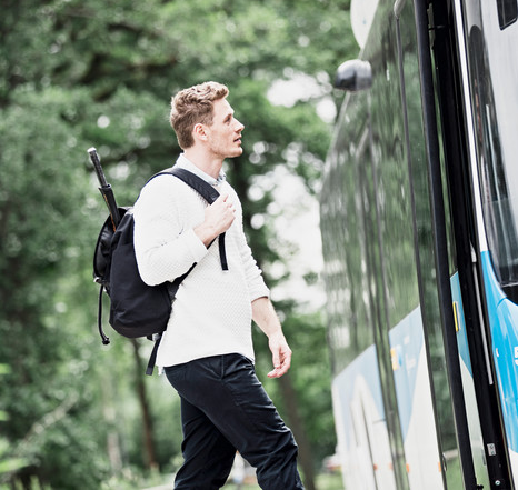 En ung man kliver på en buss.
