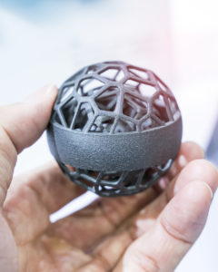En hand som håller i en 3D-printad sfär