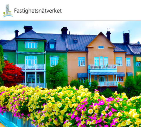 Färglada hus i grönt och orange bakom blommor i gult.